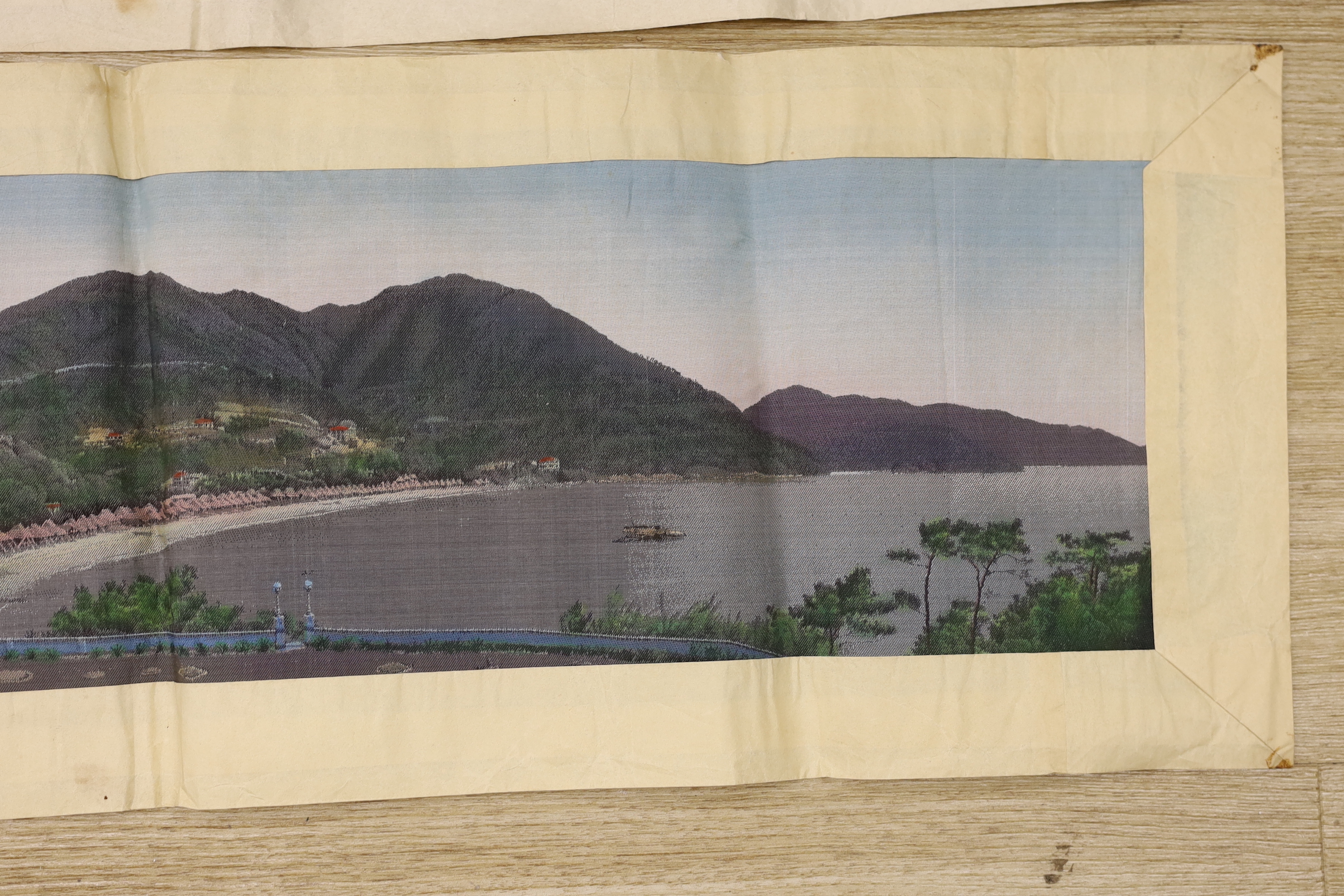 Two Chinese 1920’s machine silk panels, one depicting a contemporary Chinese coastline, the other a contemporary river scene, 71cm wide